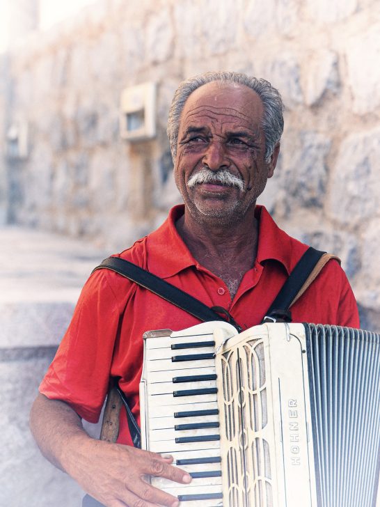 Local Greek bronzed gentleman playing accordion