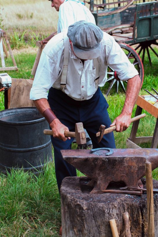 Blacksmith forming a metal horseshoe