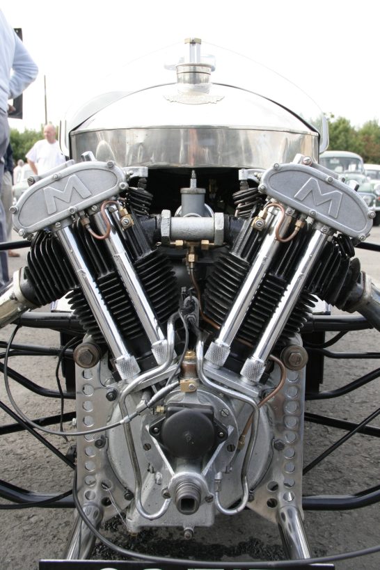 The image shows an exposed V-twin engine, installed in a vintage 1934 Morgan Super Sports three-wheeler.